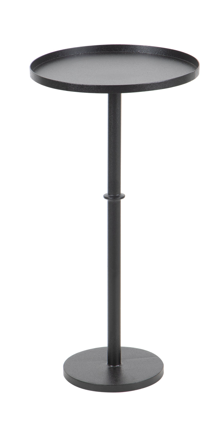 Black cast iron cocktail table seen from side in white background.