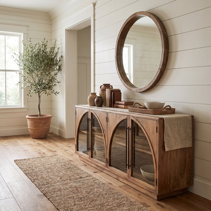 Modern farmhouse entryway featuring a wooden arched console table, round mirror, and potted olive tree on shiplap walls.